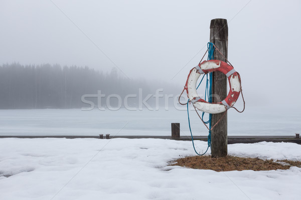 Worn-out lifesaver on post at foggy lake scape Stock photo © Juhku