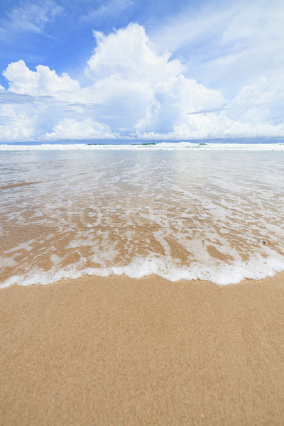 Waves sand beach and clouds sunny day Stock photo © Juhku