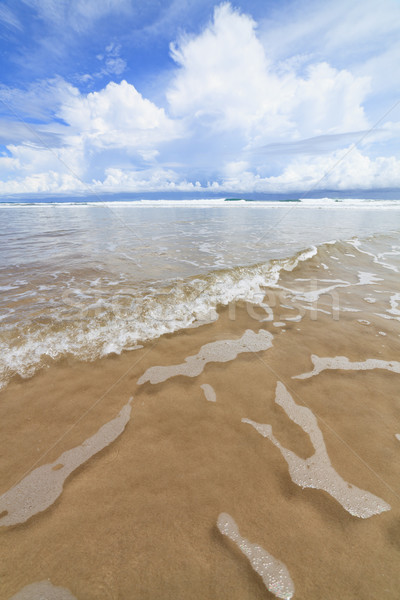 Waves sand beach and clouds sunny day Stock photo © Juhku