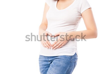 Close-up of pregnant woman embracing belly with heart shape Stock photo © julenochek