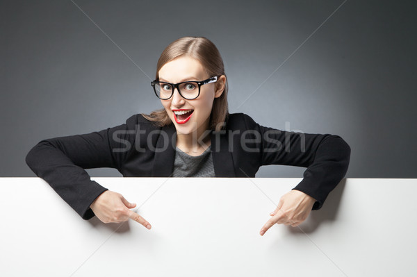 Happy woman with open mouth pointing at blank space Stock photo © julenochek