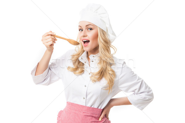 Stock photo: Chef woman tasting food from wooden spoon