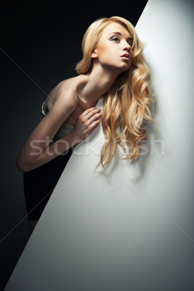 pretty blond model hiding behind a big sheet of paper Stock photo © julenochek