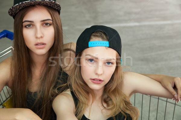 Caucasian girls in cap in cart looking at camera Stock photo © julenochek