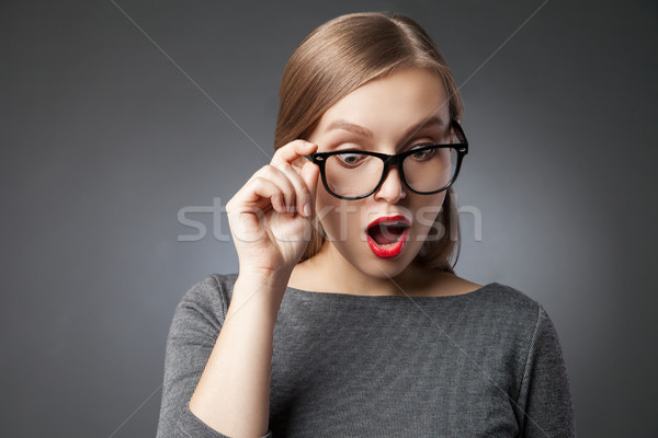 Wide-eyed woman in glasses looking down in amazement Stock photo © julenochek