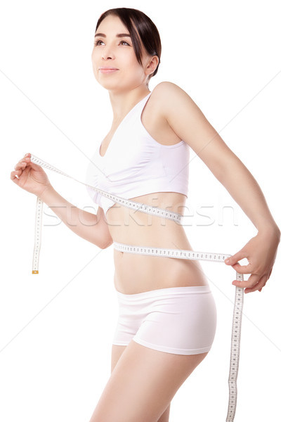 Slimming woman measuring thigh with tape Stock photo © julenochek