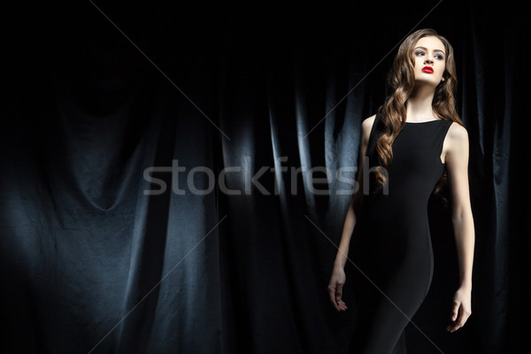 elegant woman with long wavy hair against of black cloth Stock photo © julenochek