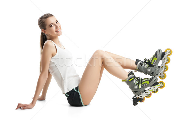 Pretty happy girl with rollerskates sitting on floor against white background Stock photo © julenochek