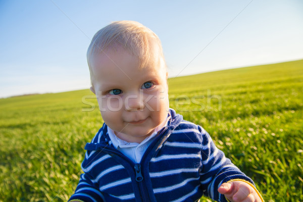 Beautiful baby boy standing in the green grass  Stock photo © julenochek