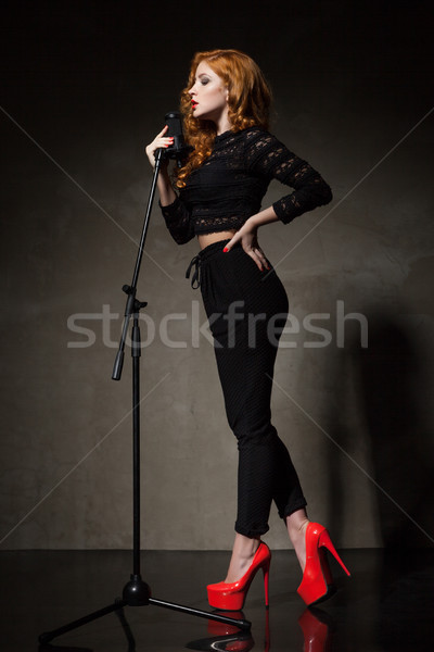 Portrait of beautiful singer in red heels and black clothes Stock photo © julenochek