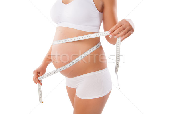 Pregnant woman measuring her stomach with tape Stock photo © julenochek