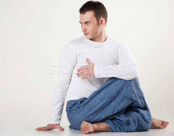 healthy young man doing yoga. Spine twisting pose Stock photo © julenochek