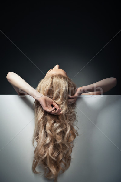 pretty blond model hiding behind a big sheet of paper Stock photo © julenochek