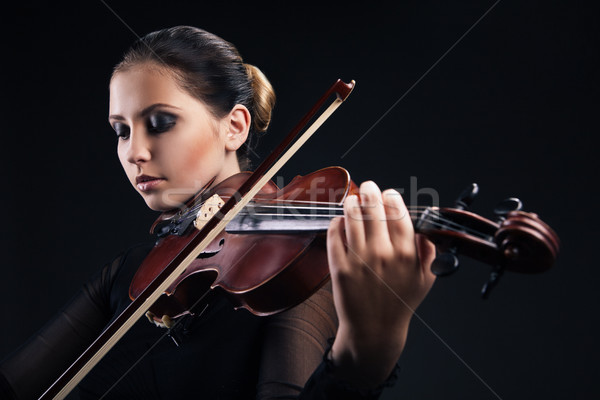 Beautiful young woman playing violin over black Stock photo © julenochek
