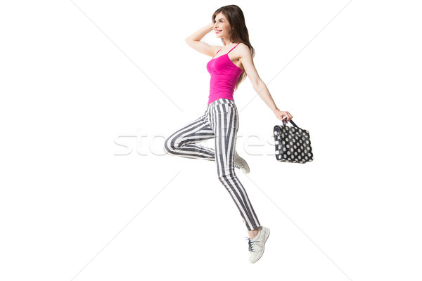 Smiling model holding polka dot bag while jumping Stock photo © julenochek