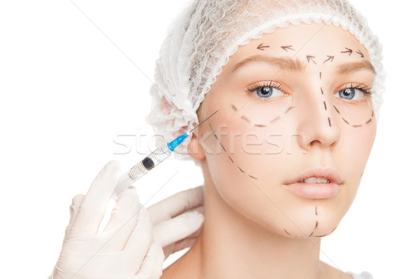 Surgeon injecting woman's face with outlines Stock photo © julenochek