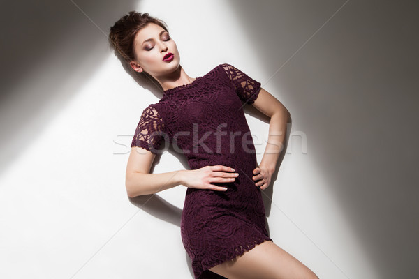 Beautiful model in purple dress with eyes closed on floor Stock photo © julenochek