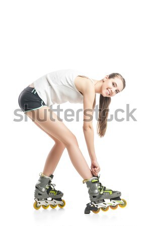 Pretty happy girl with rollerskates sitting on floor against white background Stock photo © julenochek