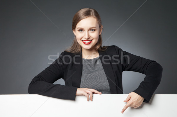 Smiling beautiful woman pointing at blank space Stock photo © julenochek