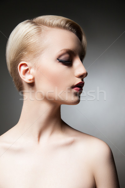 Stock photo: Beautiful young model with make-up and hairstyle looking down