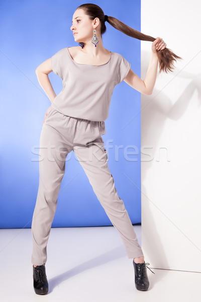 Young model in overall posing while holding long tail Stock photo © julenochek