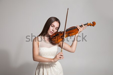Beautiful young woman playing violin over white Stock photo © julenochek