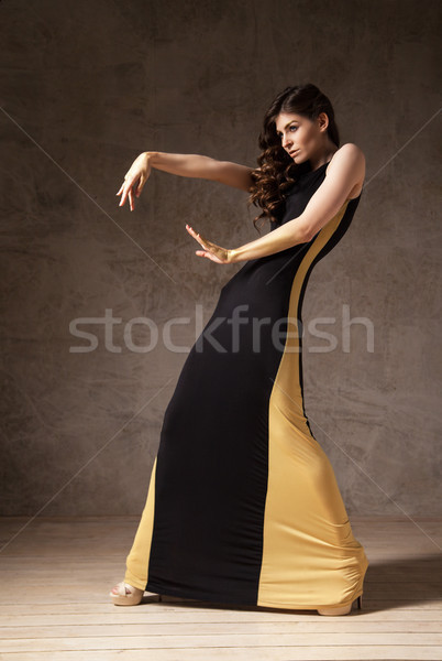 fashion model with wavy hair wearing long dress and gesturing by arms Stock photo © julenochek