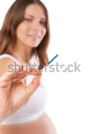 Uśmiechnięty młoda kobieta patrząc test ciążowy odizolowany kobieta Zdjęcia stock © julenochek