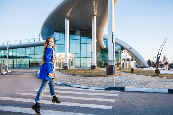 Side view of brunette in blue coat jumping on crosswalk Stock photo © julenochek