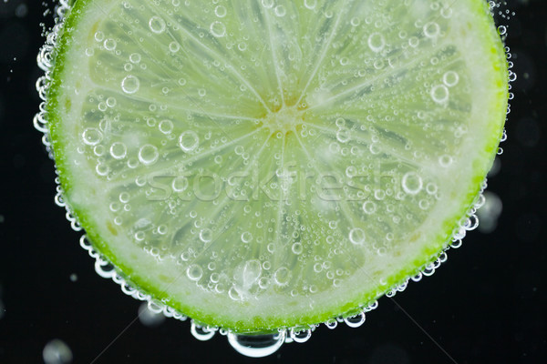 Lime slice falling into water Stock photo © juniart