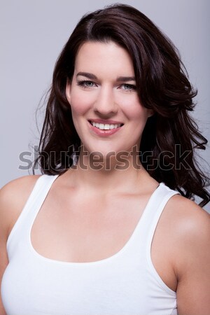 Portret piękna kobieta ciemne włosy uśmiechnięty kamery szary Zdjęcia stock © juniart