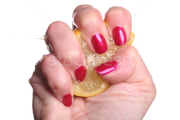 Hand with manicured nails squeeze lemon on white Stock photo © juniart