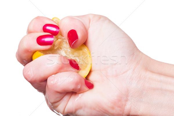 Hand with manicured nails squeeze lemon on white Stock photo © juniart