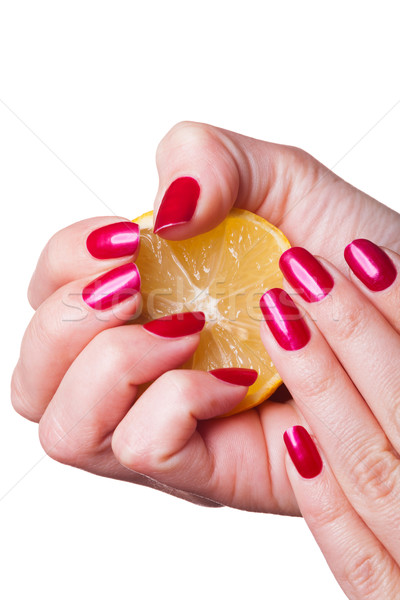 Hand with manicured nails squeeze lemon on white Stock photo © juniart