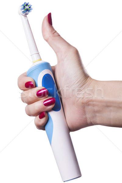 Hand holds electric toothbrush against white Stock photo © juniart