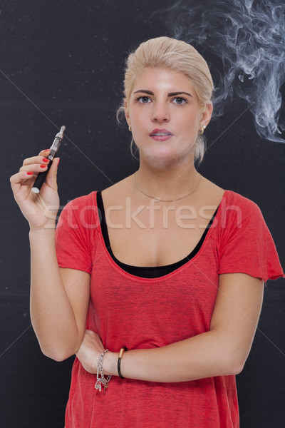 Stylish blond woman smoking an e-cigarette Stock photo © juniart