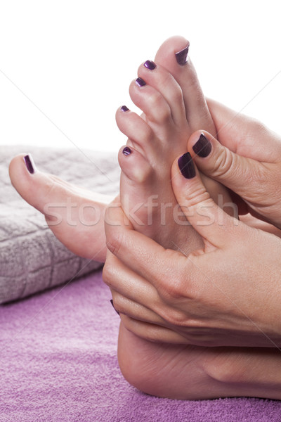 Manicured hands stroke bare feet with nail polish Stock photo © juniart