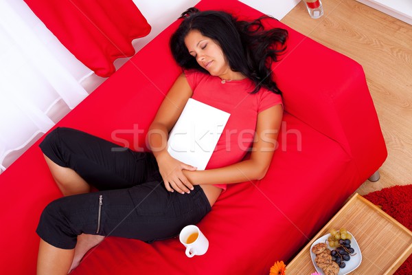 Fatigué jeune femme livre canapé cheveux [[stock_photo]] © kalozzolak