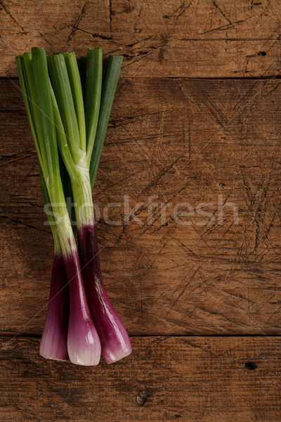 Green spring onions on wooden table Stock photo © kalozzolak