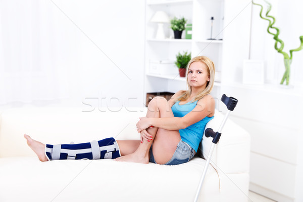 Meisje been letsel vergadering sofa home Stockfoto © kalozzolak