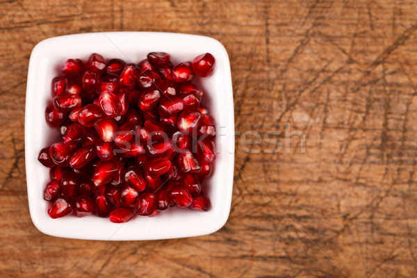 Red grenadine seeds on white plate Stock photo © kalozzolak