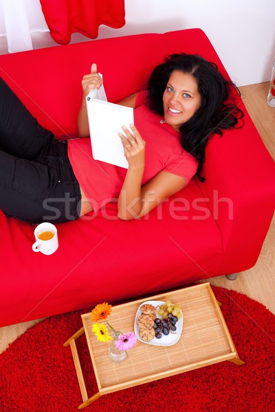 Przyjemność czytania młoda kobieta sofa książki kobieta Zdjęcia stock © kalozzolak