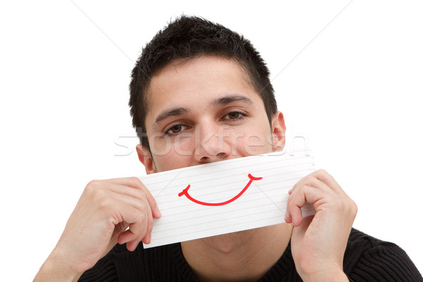 A smiling paper in the hand of a young man Stock photo © kalozzolak