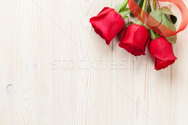 Red roses over wooden table Stock photo © karandaev