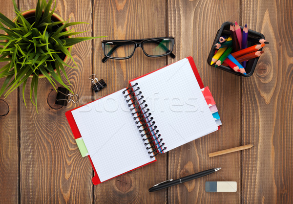 Office table with notepad, colorful pencils, supplies and flower Stock photo © karandaev