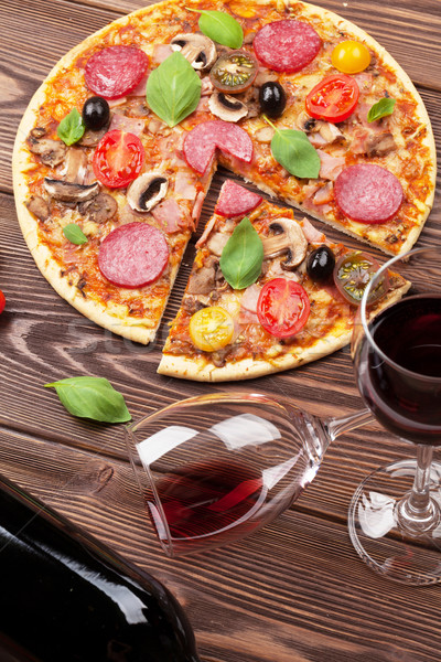 Stock photo: Italian pizza with pepperoni, tomatoes, olives, basil and red wi