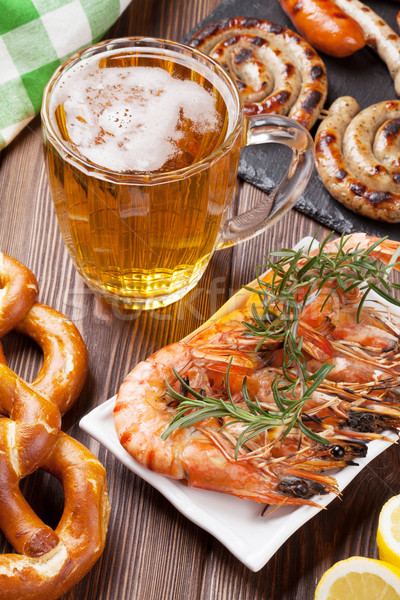 Beer mug, grilled shrimps, sausages and pretzel Stock photo © karandaev