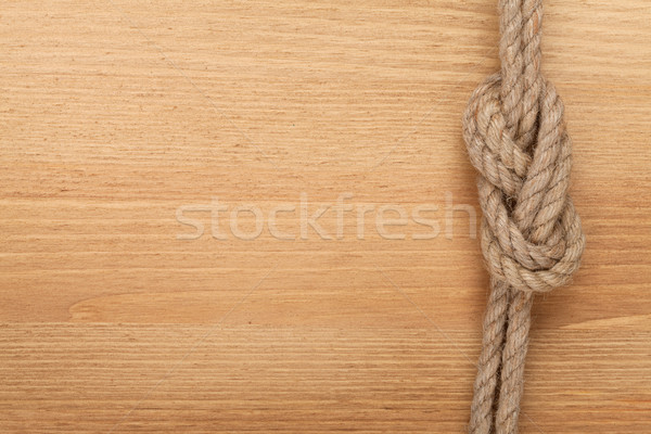 Ship rope knot on wooden texture background Stock photo © karandaev