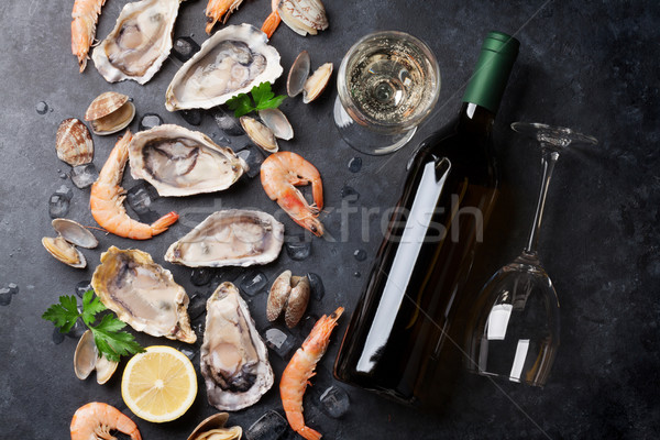 Fresh seafood and white wine on stone table Stock photo © karandaev