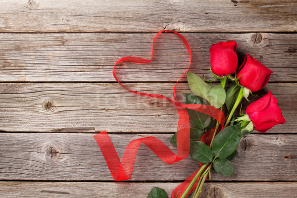 Red roses and heart shape ribbon over wood Stock photo © karandaev